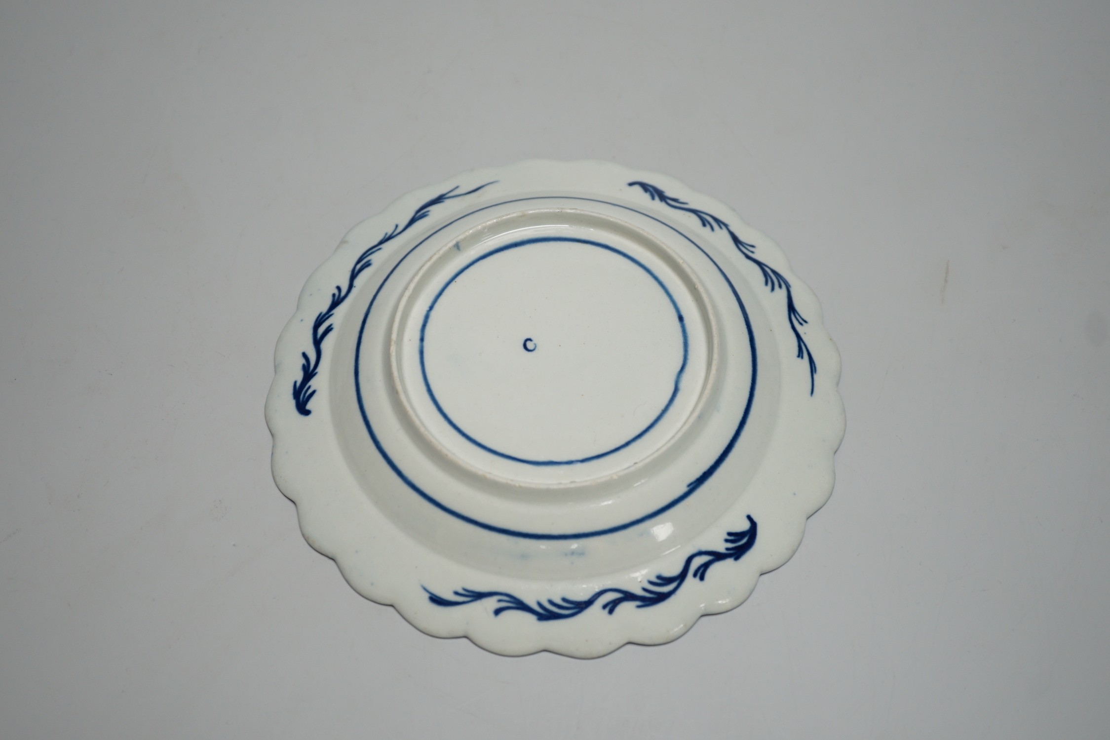 An 18th century Caughley plate painted with Scholars Rock, C mark, verso, 18cms diameter